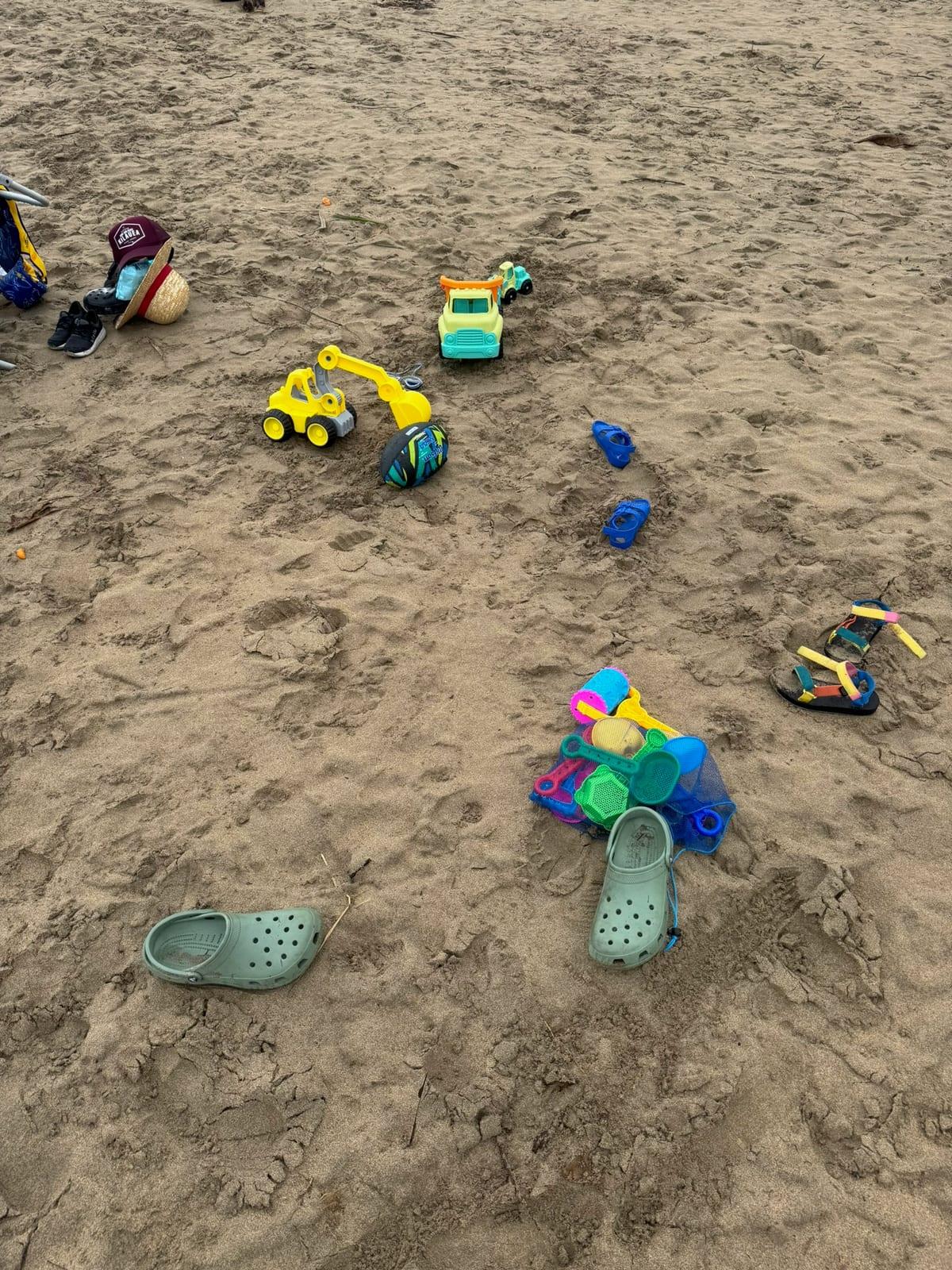Kids' beach toys and Crocs set in the sand, the kind of simple setup that makes a Princeville family beach day easier