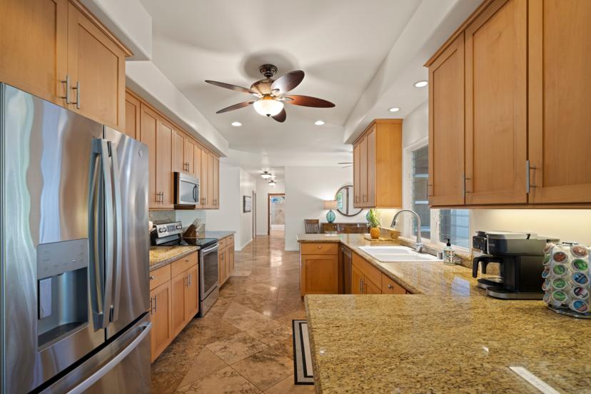 Full kitchen with stainless fridge and twin ceiling fans, Princeville rental