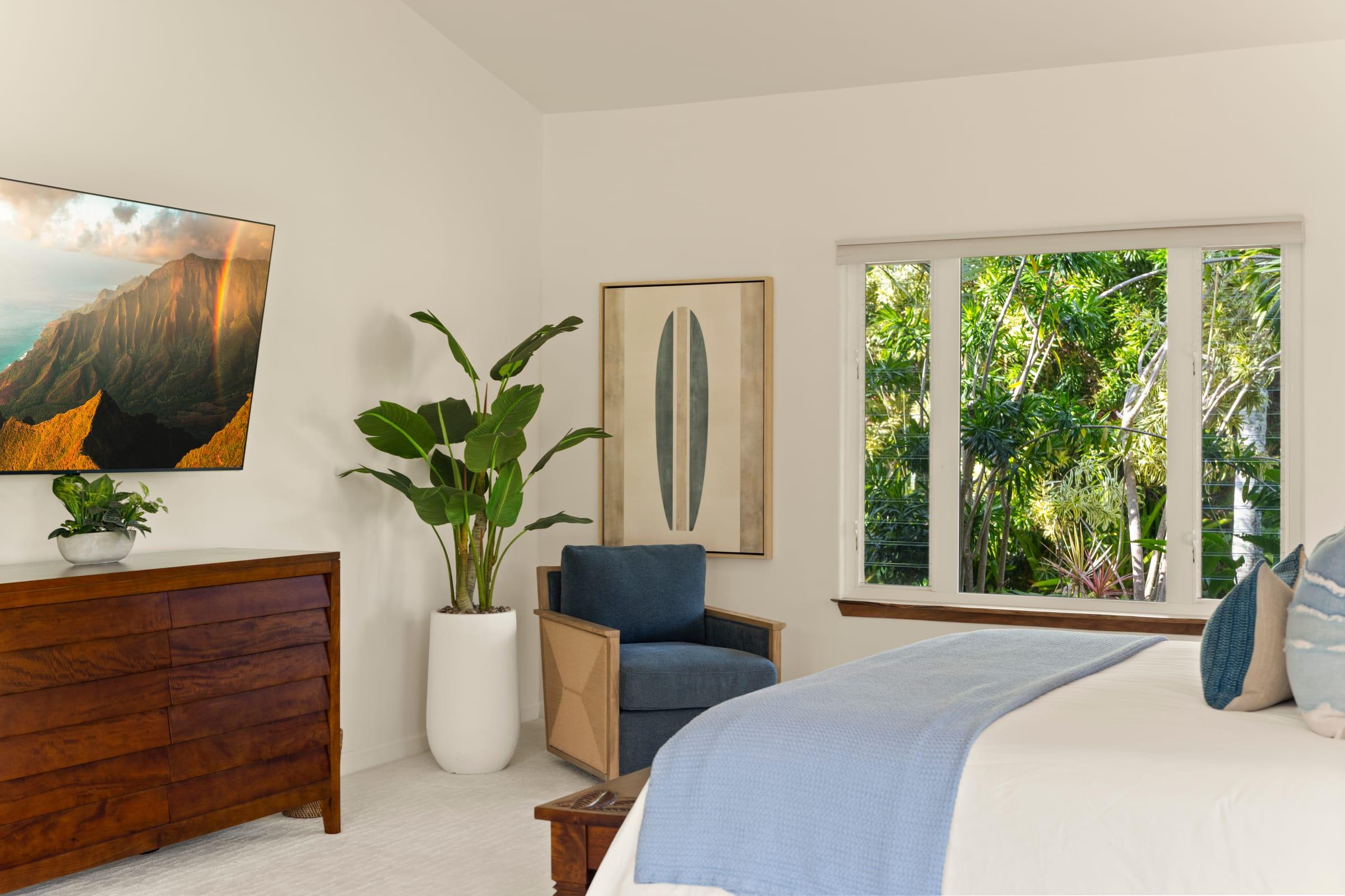 Primary bedroom at Emmalani Hale with a king bed and tropical decor in Princeville, Kauai