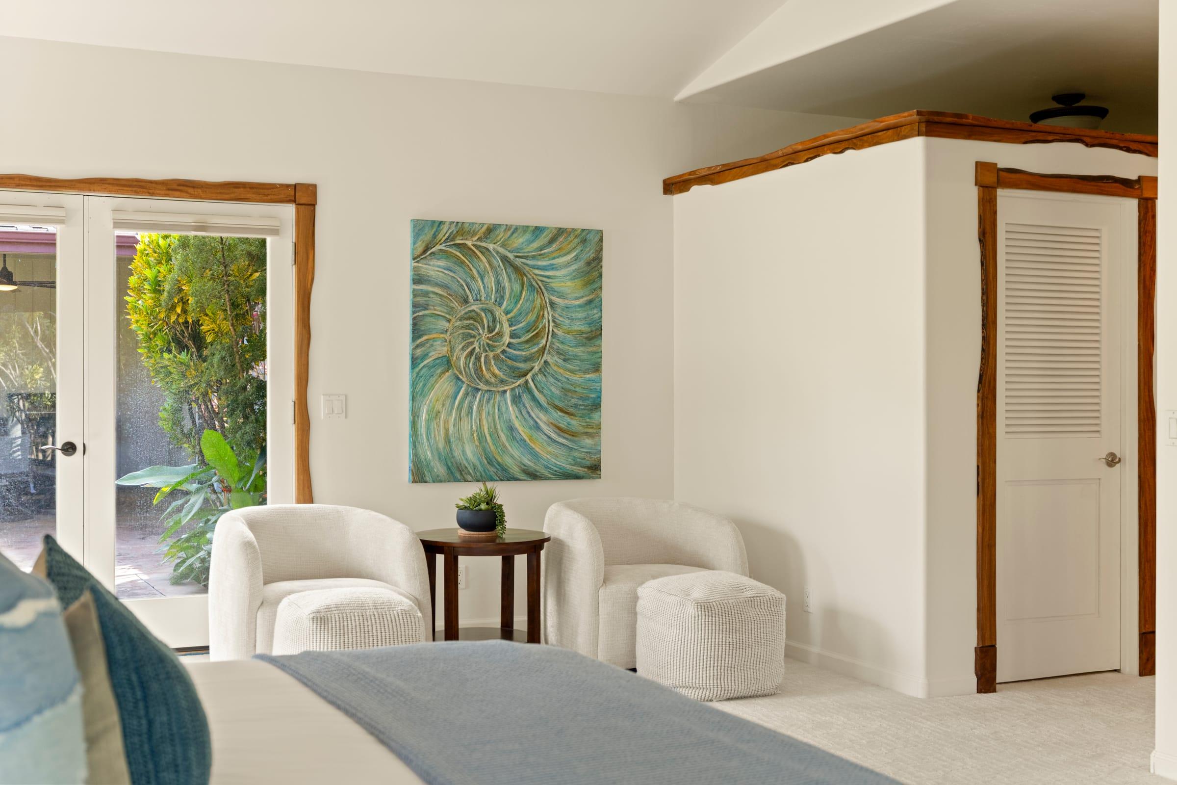 Master suite sitting nook with French doors opening flat to the lanai at Emmalani Hale, a single-level Princeville rental