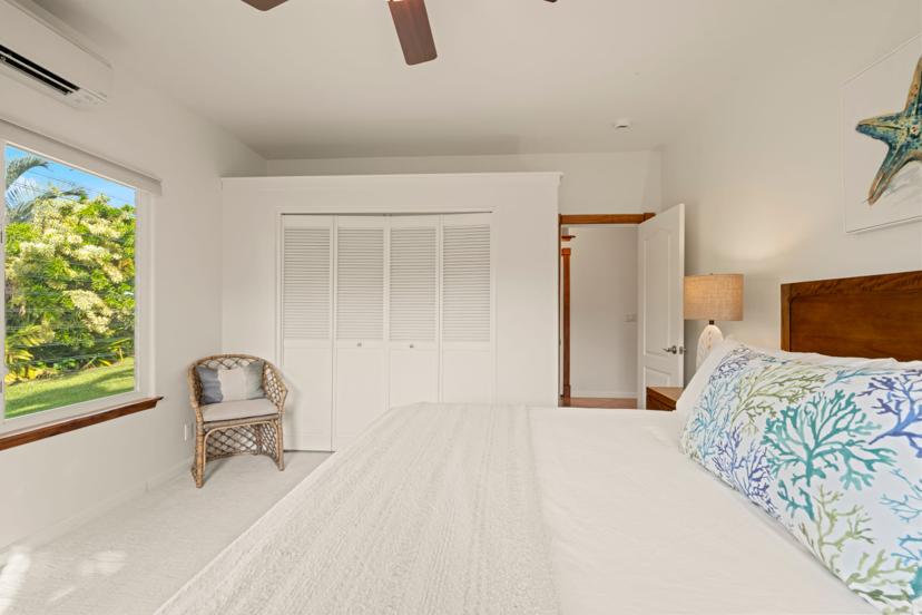 Guest bedroom with garden view and reading chair, Princeville vacation home