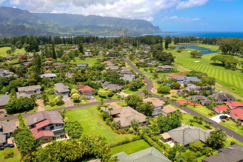 Aerial view over Princeville with Hanalei Bay and mountains in the distance