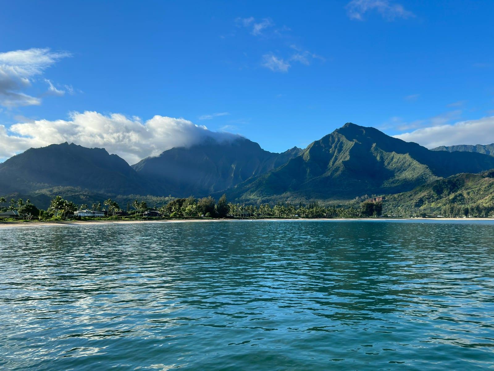 Hanalei Bay seen from the water with the beach and North Shore mountains, near Princeville, Kauai