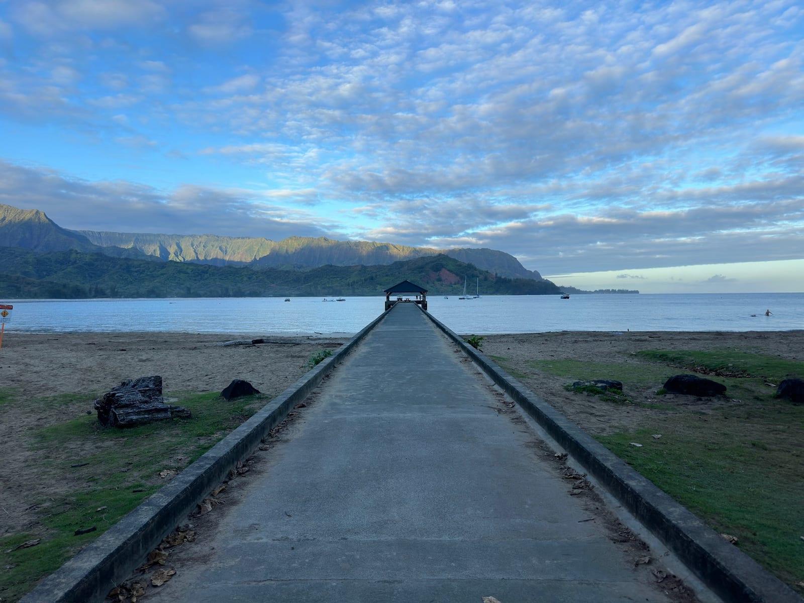 Hanalei Pier reaching into the bay at dawn, mountains behind, about 10 minutes from Princeville